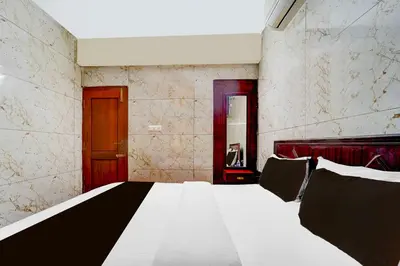 a bedroom with a large bed in a room at Hotel O Gandhipuram Central Bus Stand in Coimbatore