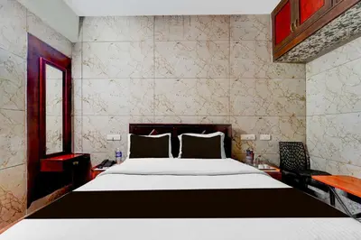 a bedroom with a large white bed in a room at Hotel O Gandhipuram Central Bus Stand in Coimbatore