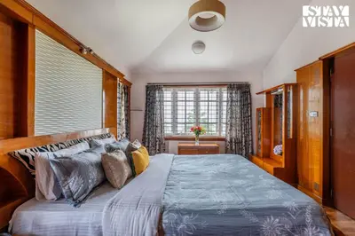 a bedroom with a large bed and a window at The Secret Glen by VEO - Part of StayVista with BBQ & Bonfire in Ooty