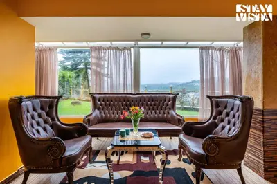 two leather chairs and a couch in a living room at The Secret Glen by VEO - Part of StayVista with BBQ & Bonfire in Ooty