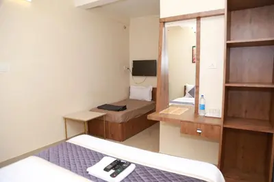 a small room with two beds and a mirror at Haaz Grande Kunnamangalam in Kunnamangalam