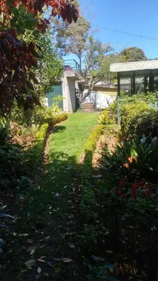 a yard with a house and a garden with grass and flowers at Glenwood in Coonoor