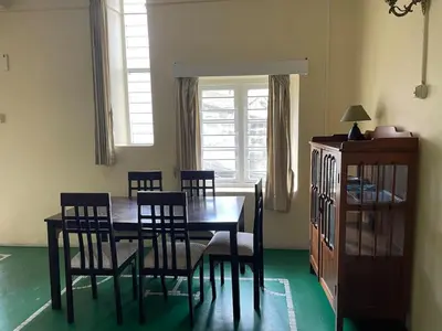 a dining room with a wooden table and chairs at Glenwood in Coonoor