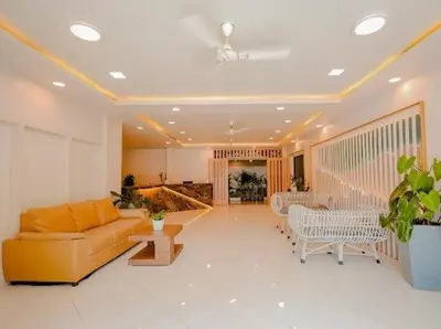 a living room with a couch and a table at Whitelake Resort in Bilikere