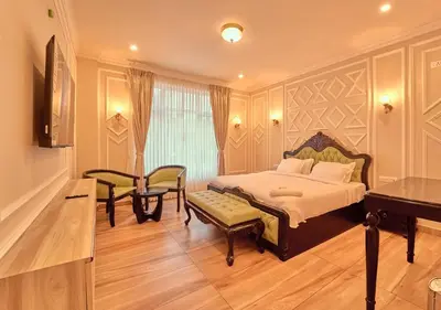 a bedroom with a bed and a table and a piano at King Palace Ooty by VOYE HOMES in Ooty