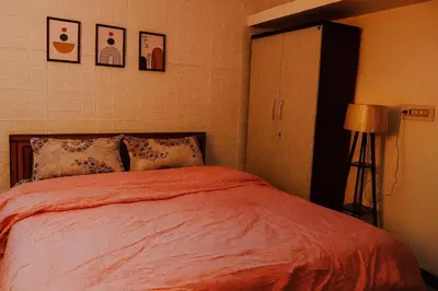 a bedroom with a bed with an orange blanket at Pleasant Heights Homestay in Coonoor