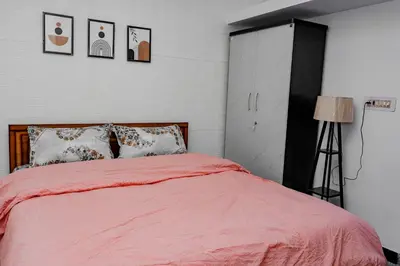 a bedroom with a bed with a red comforter at Pleasant Heights Homestay in Coonoor