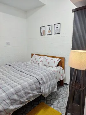 a bedroom with a bed with a blanket and a lamp at Pleasant Heights Homestay in Coonoor