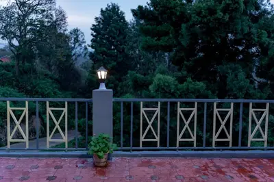 a light on a fence with a potted plant at Pleasant Heights Homestay in Coonoor
