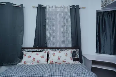 a bed with a black headboard and two pillows at Pleasant Heights Homestay in Coonoor