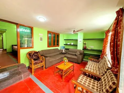 a living room with a couch and a table at GSC Family Holiday Home in Pollāchi