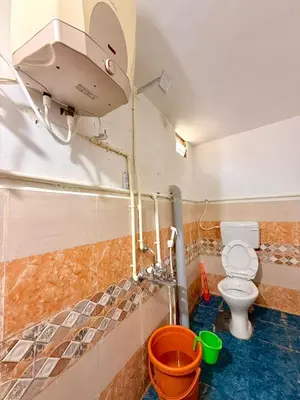 a small bathroom with a toilet and a shower at GSC Family Holiday Home in Pollāchi