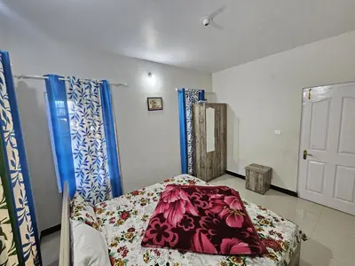 a bedroom with a bed with a blanket on it at Sait's Westhill View Resort in Ooty