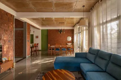 a living room with a blue couch and a table at Tranquil Nest in Kozhikode