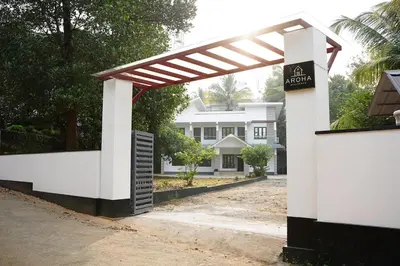 a white house with a pergola in front of it at Aroha Residence - Sleek and Spacious Wayanad Villa in Kalpetta