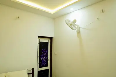a room with a ceiling fan on the wall at Aroha Residence - Sleek and Spacious Wayanad Villa in Kalpetta