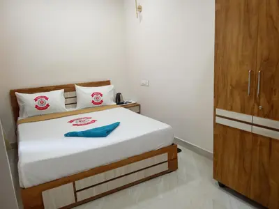 a bedroom with a bed and a wooden cabinet at Benzy Tourist Home in Ponnāni