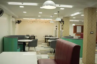 a restaurant with tables and chairs in a room at Benzy Tourist Home in Ponnāni