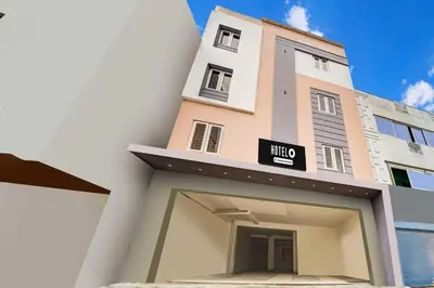 a tall building with a garage in front of it at Hotel O Coimbatore Brookefields Mall in Coimbatore