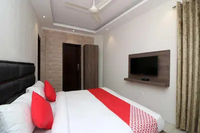 a bedroom with a bed with red pillows and a tv at Hotel O Chalakkudy River Annamanada Svasthya Retreat in Māla