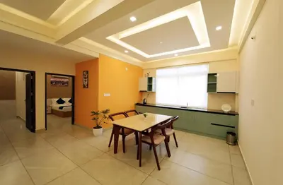 a kitchen with a table and chairs in a room at Revoura Heights Apartments in Sultan Bathery
