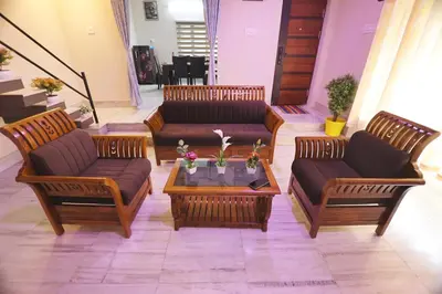 a living room with couches and a coffee table at Tranquil Rest House in Trichūr