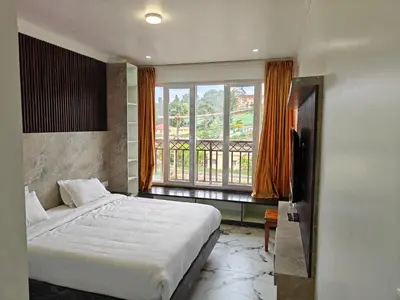 a bedroom with a bed and a large window at The Ooty Suites in Ooty