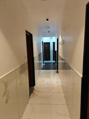 a hallway with a tile floor and a hallway with black doors at The Ooty Suites in Ooty