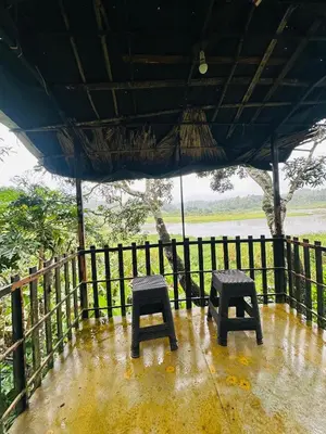 a pair of stools sitting under an umbrella at Greenery Holiday Homes in Meppādi