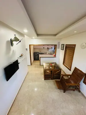 a living room with a table and a couch at Greenery Holiday Homes in Meppādi