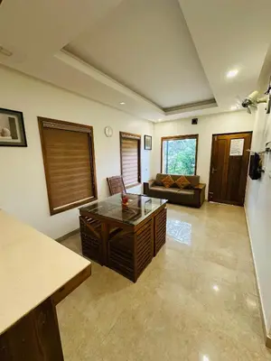 a living room with a coffee table and a couch at Greenery Holiday Homes in Meppādi