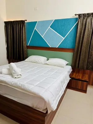 a bedroom with a large bed with white sheets at Marvee Luxus Stay in Coimbatore