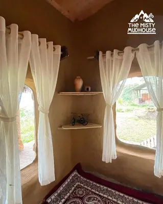 a room with two windows with curtains and a rug at The Misty Mudhouse in Marayoor