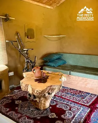 a living room with a table and a couch at The Misty Mudhouse in Marayoor