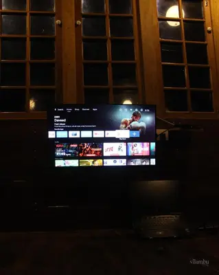 a television screen in a dark room with windows at Nilambu Homestay in Nilambūr