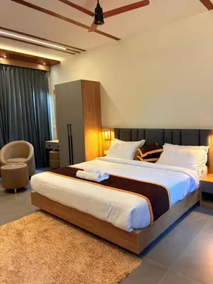 a bedroom with a large bed in a room at Cozycaza resort in Padinjarathara