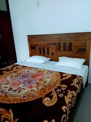 a bedroom with a bed with a floral bedspread at Staycation Homestay in Ernakulam