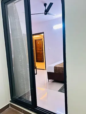 a glass door with a view of a bedroom at Queens Suite Rooms in Channapatna