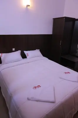 a large bed with white sheets and towels on it at PVR International in Coimbatore