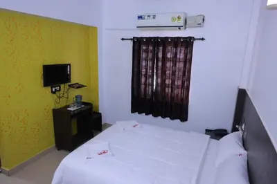 a bedroom with a white bed and a television at PVR International in Coimbatore