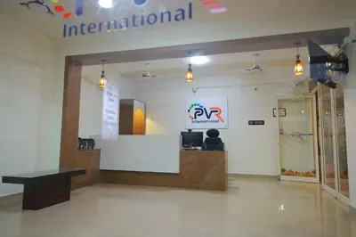 an office with a reception desk and a sign on the wall at PVR International in Coimbatore