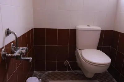 a bathroom with a toilet in a tiled room at PVR International in Coimbatore