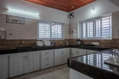 a large kitchen with a large counter top and windows at Sree Bharat Apartment in Coimbatore