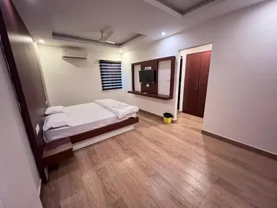 a bedroom with a bed and a television in it at FARIS ROOMs in Malappuram