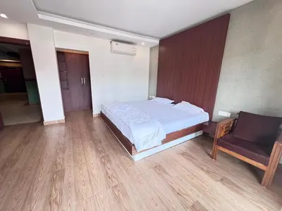a bedroom with a bed and a chair in it at FARIS ROOMs in Malappuram