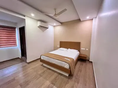 a bedroom with a bed and a ceiling fan at FARIS ROOMs in Malappuram