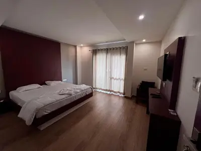a bedroom with a bed and a large window at FARIS ROOMs in Malappuram
