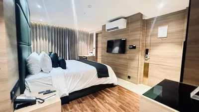 a bedroom with a bed and a tv in a room at Oshin Calicut in Kozhikode