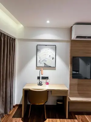 a hotel room with a desk and a tv at Oshin Calicut in Kozhikode