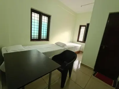 a room with a couch and a table and a chair at bohom STAYORA in Nedumbassery